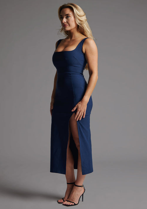Side front image of a model wearing the Vesper Abbie Square Neck Midaxi Dress in Navy, highlighting the sculpting fit and fluid fabric movement