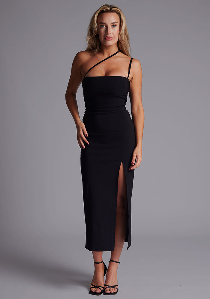 Front image of a model wearing the Vesper Abigail Cross Strap Midaxi Dress in Black with a straight neckline, delicate cross-strap detail, and a form-skimming silhouette against a neutral studio backdrop.