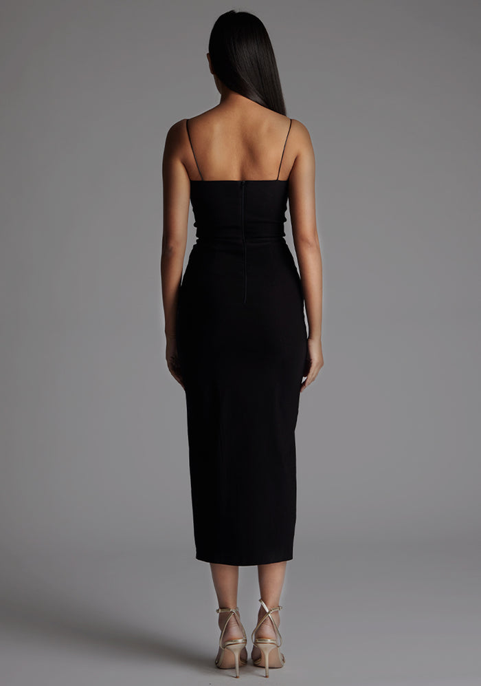 Back image of a model wearing the Vesper Adeline Cut Out Midaxi Dress in Black, displaying the slim straps, fitted waist, and sleek midaxi length.