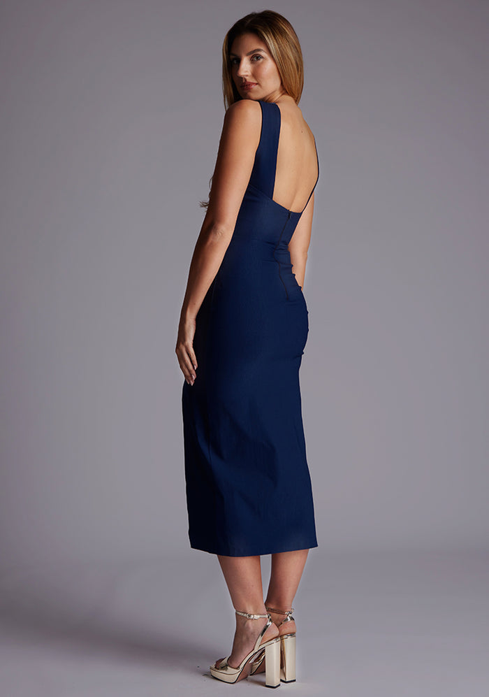 Side back image of a model wearing the Vesper Aida Cross Neck Midaxi Dress in Navy, showing the crossover neckline and contemporary open-back design.