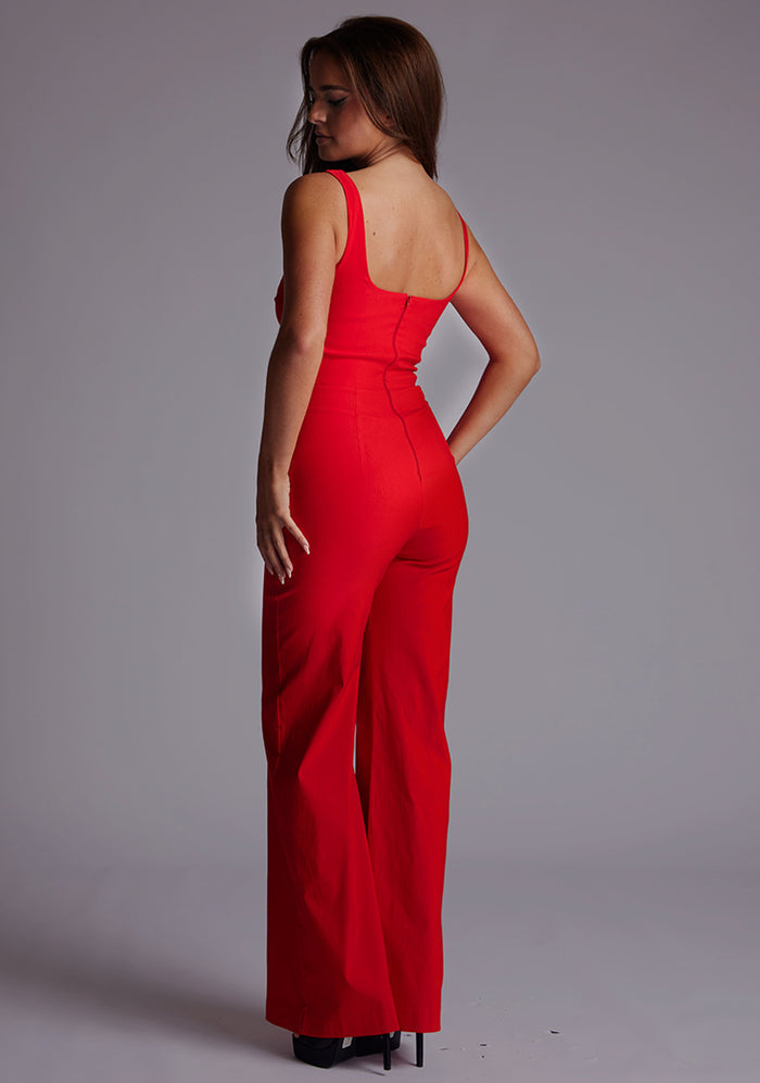 Side back image of a model in the Vesper Alana Square Neck Wide Leg Jumpsuit in Red, showing the smooth back line and flowing wide leg finish