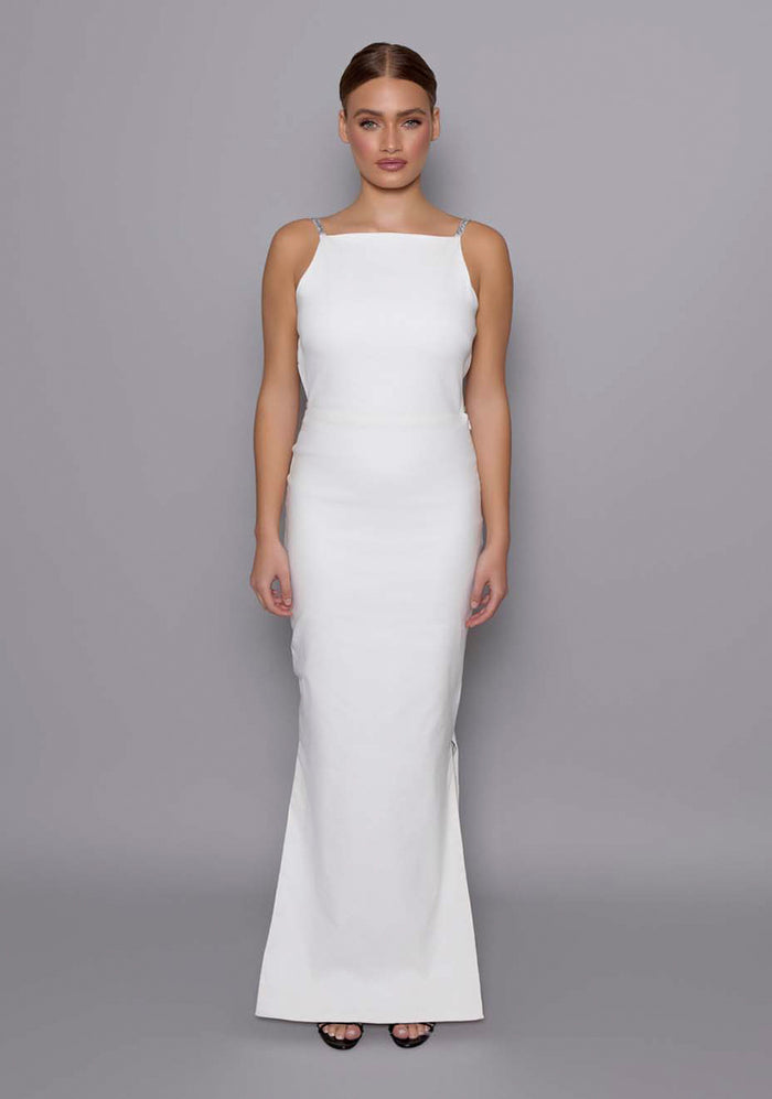 Model wearing the VSPR Alba Ivory open-back maxi dress with a sleek high square neckline and figure-skimming silhouette, against a soft grey studio backdrop.