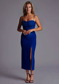 Front image of a model wearing a cobalt midaxi dress with a charming sweetheart neckline with a ruched front design, delicate thin straps and graceful front skirt split. The design featured is the Vesper Alex Cobalt Midaxi Dress