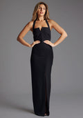 Front image of a model wearing the Vesper Amira Halter Neck Maxi Dress in Black, featuring with a slim-fit crepe fabric, shoulder-framing halter neckline, and front skirt split for an elongated silhouette, pose against a grey studio backdrop.