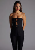 Close-up image highlighting the Vesper Augusta Bandeau Longline Top in Black, showcasing the smooth stretch fabric, clean strapless neckline, and subtle front cut-out detail, standing against a grey studio backdrop.