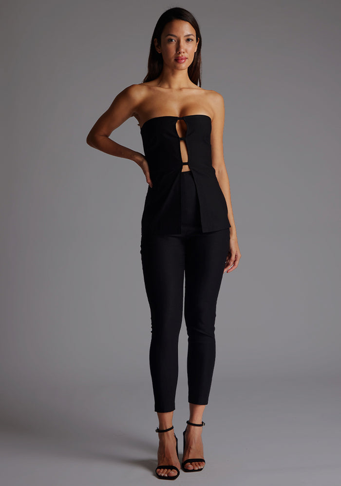 Front image of a model wearing the Vesper Augusta Bandeau Longline Top in Black, featuring a strapless neckline, longline cut, and sculptural silhouette, posing against a grey studio backdrop.