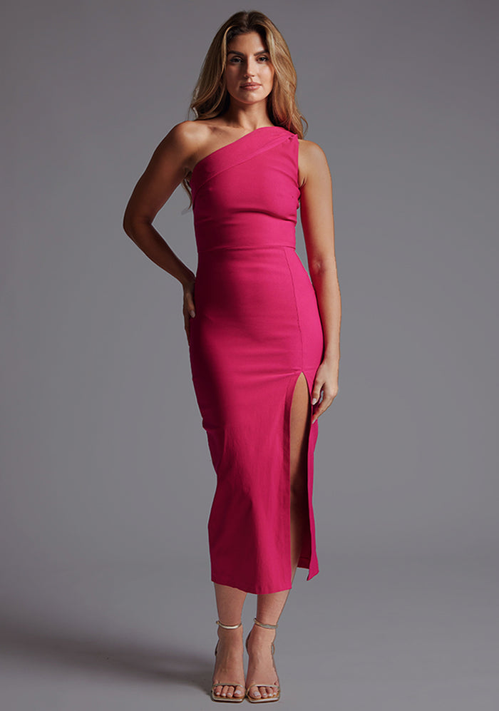 Front image of a model wearing the Vesper Ava One Shoulder Midaxi Dress in Cerise with an asymmetric neckline, thigh-high split, and sleek midaxi silhouette. against a grey studio backdrop.