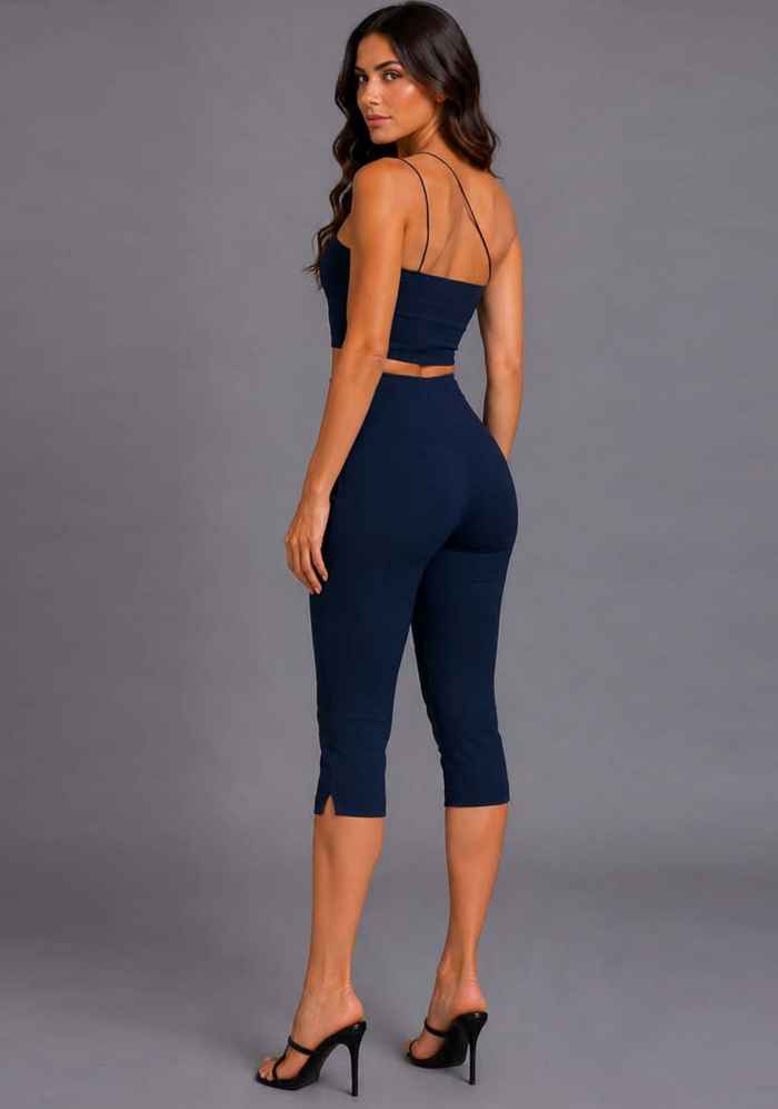 Side back image of a model wearing the VSPR Avalon Asymmetric Strap Navy Crop Top, featuring the elegant asymmetric strap design and smooth fitted shape against a grey studio backdrop.