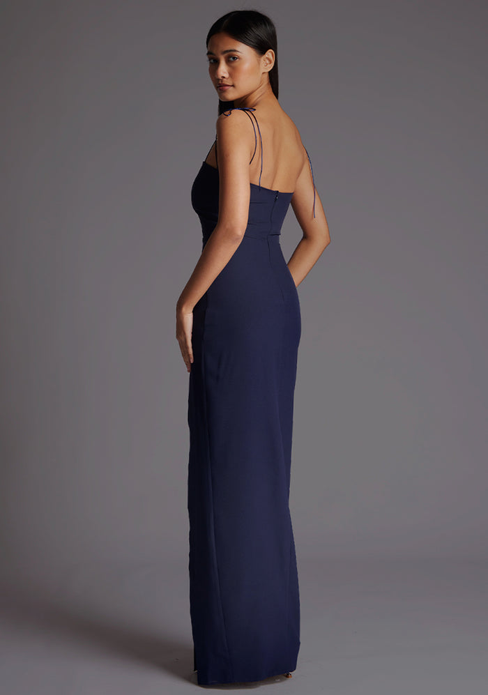 Side back image of a model wearing the Vesper Bronte Tie Strap Maxi Dress in Navy, showcasing the clean back lines, tie strap detail, and fluid maxi silhouette.