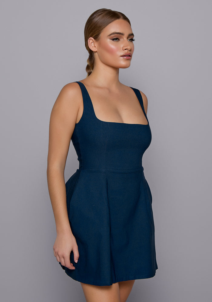 Close-up side-front view of the VSPR Camille Dress focusing on the square neckline, structured bodice, and soft flare starting at the waist.