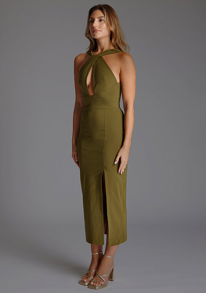 Side front image of a model wearing the Vesper Carter Halterneck Bodycon Midaxi Dress in Olive, highlighting the sculpted fit, front cut-out and fluid skirt movement.