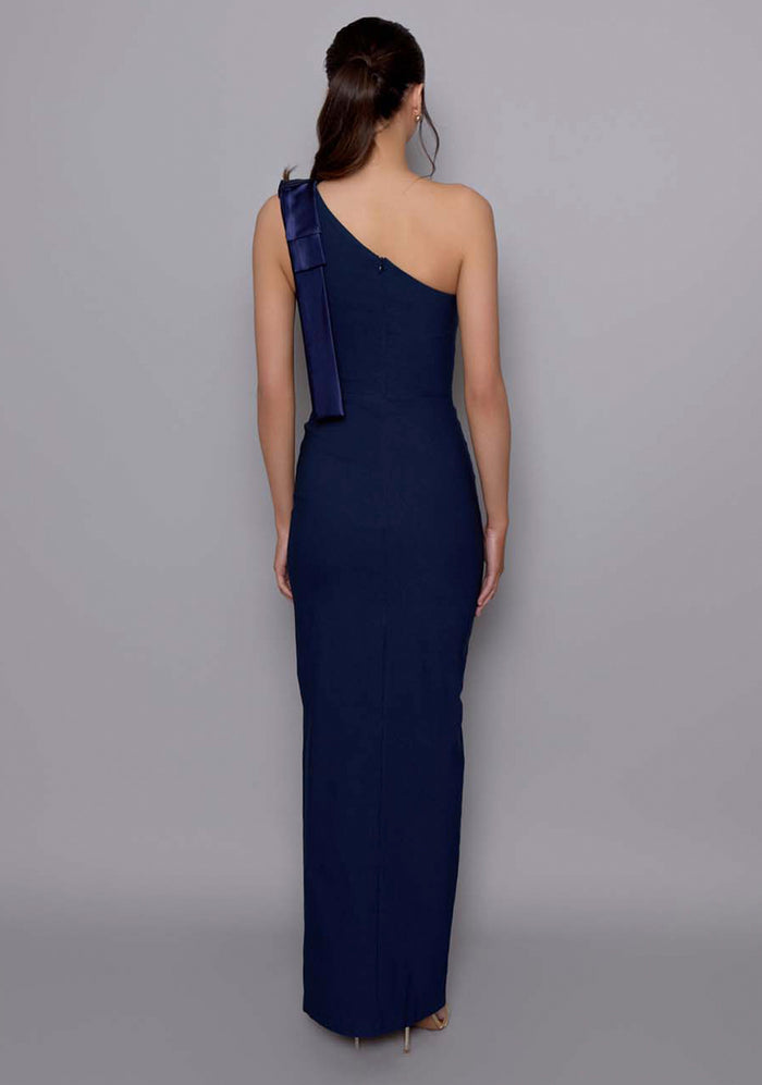 Back view of the VSPR Cedar dress revealing the fitted back panel and precise tailoring along the side seam, with the bow shoulder detail visible from the angle.