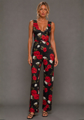 Front view of a model wearing the VSPR Noelle Black Floral Wide Leg Jumpsuit featuring a flattering V neckline, oversized floral print, and flowing wide leg trousers against a grey studio backdrop.